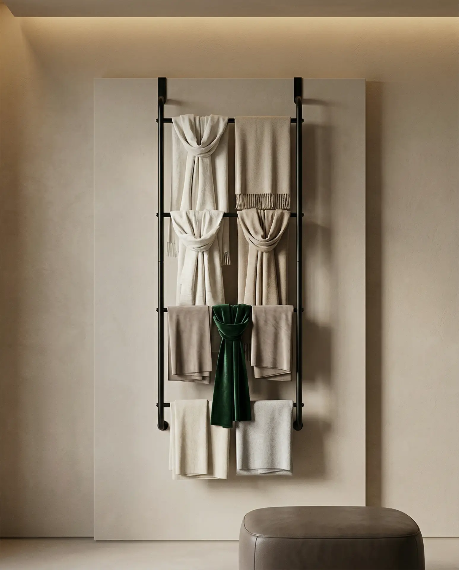 The Drape scarf rack in blackened steel, wall mounted with folded and knotted scarves in ivory, stone and deep green